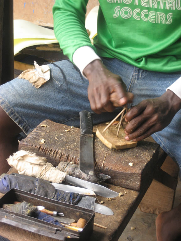 Adding raffia to form a handle for the adinkra stamp