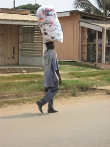 Man carrying a bag of laundry on his head