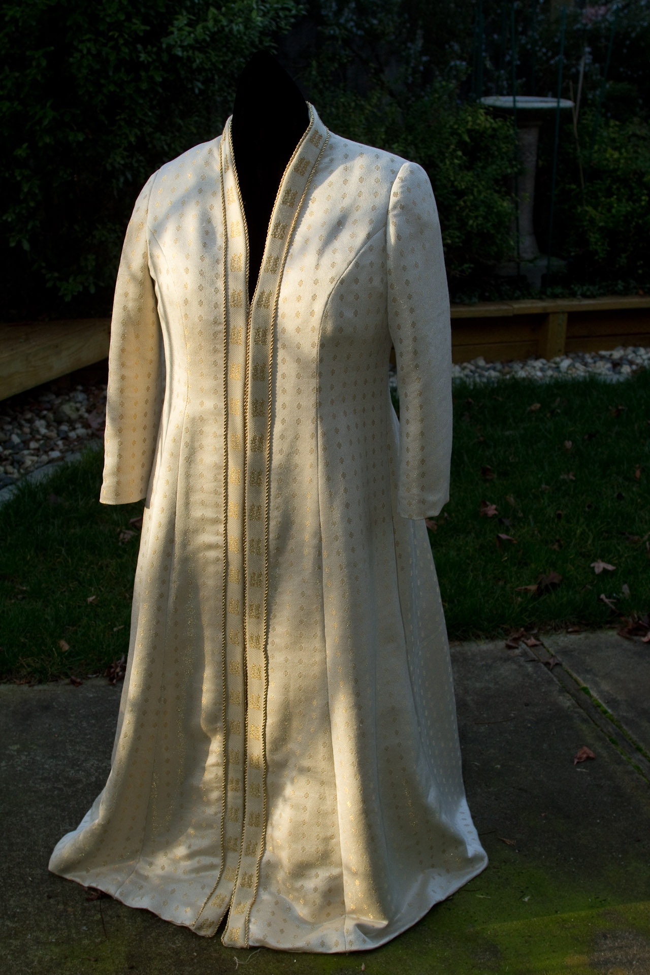 Handwoven wedding coat, draped over dress form