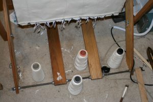 Cones of yarn on the floor, directly under the beater.  (Please ignore the mess.)
