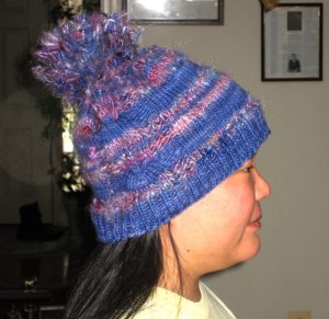 Knitted funky hat with pom pom, side view