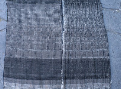 Plain weave and waffle weave, networked and allover pattern, with white overtwisted wool weft, beaten firmly.  Warp is black 60/2 silk sett at 40 epi.