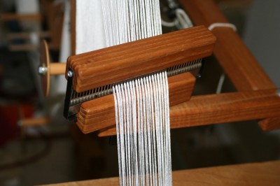 The warping wheel comb, with the peg only partially inserted so it doesn't split the yarn as it winds on.