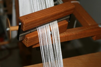 The warping wheel comb, with the peg fully inserted. Notice how it splits the yarn.