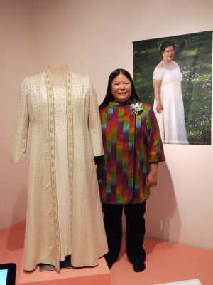 Tien with her wedding dress at the museum exhibit