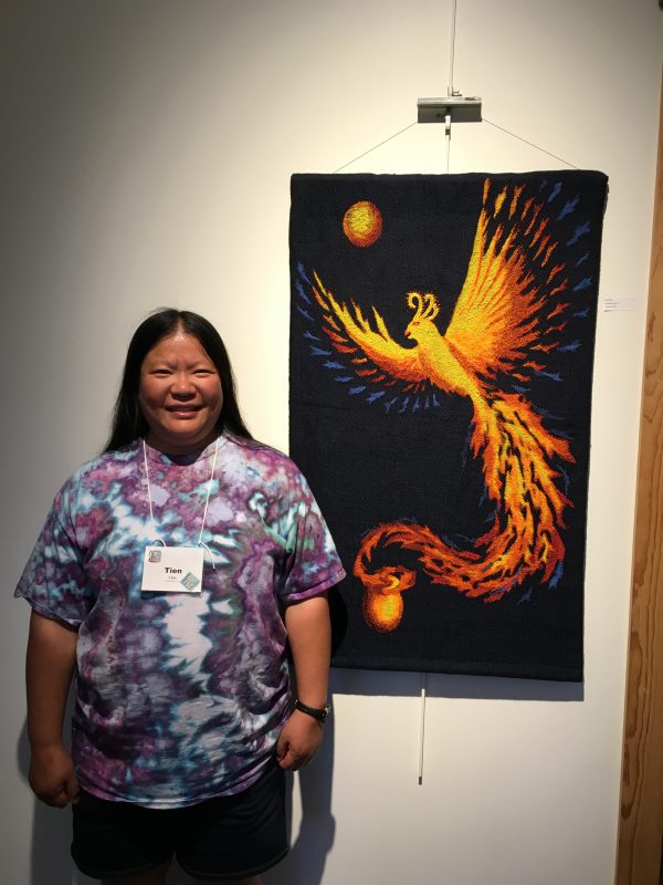 Tien with phoenix piece "Goodbye, Ma!" at The Fine Line Creative Arts Center