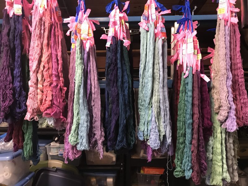 Sun Yellow, Fuchsia, Navy Blue dyed skeins hanging up to dry