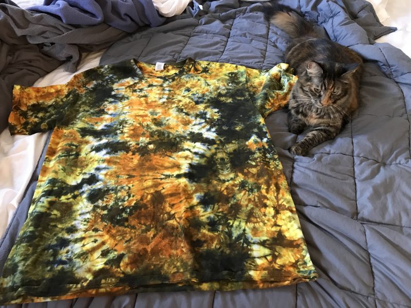 Tigress with a black, orange, and yellow scrunch-dyed tie-dye shirt