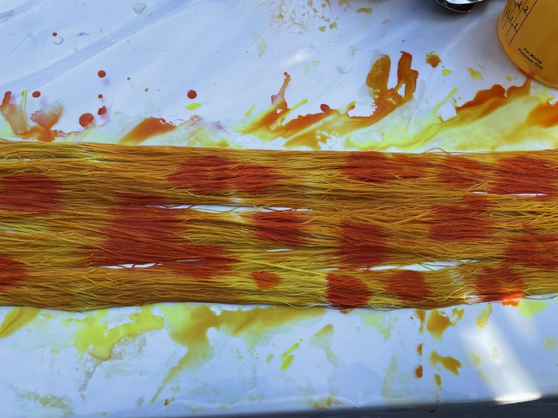 warp with dabs of orange dye