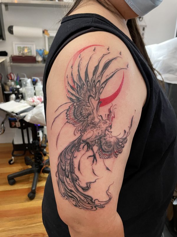 black parts of phoenix tattoo finished, red parts partially filled in