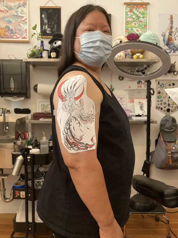 Tien with tattoo image taped to her arm